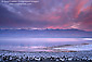 Pink clouds at sunrise over flooded basin in spring, near Badwater, Death Valley National Park, California