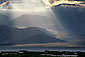 Clouds and Crepuscular Rays Sunbeams on Alluvial fan and hills at sunset, Death Valley National Park, California
