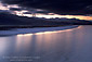 Evening light and storm clouds at sunset over water in flooded Middle Basin, Death Valley National Park, California