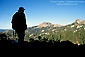 Hiker overlooking mountain peaks and forest on trail to Bumpass Hell, Lassen Volcanic National Park, California