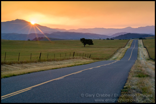 Photo: Golden sunrise light over long straight two lane country road and rolling hills in Spring, Santa Ynez Valley, California